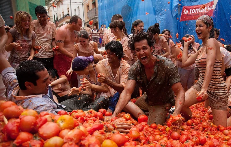 Crowds of people drenched in tomato pulp mid-battle at La Tomatina in Bunol, Spain