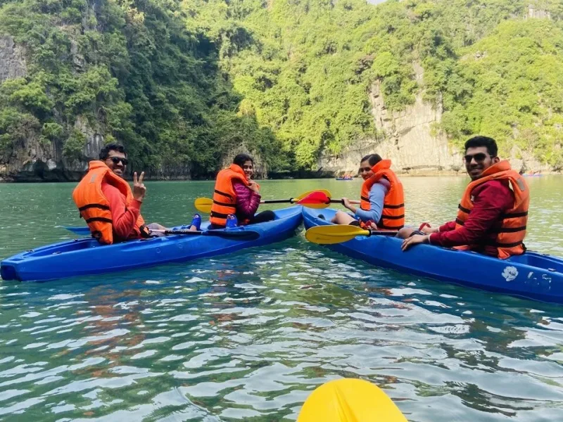 OJ group kayaking through limestone karsts in Halong Bay, Vietnam, in orange life jackets