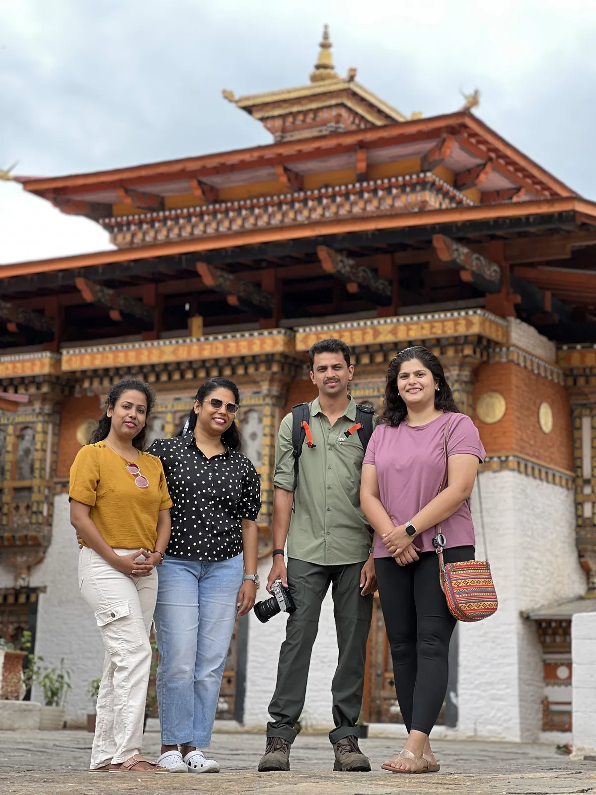 Friends posing front on the Bhutan group trip with One in the Orange Jacket.