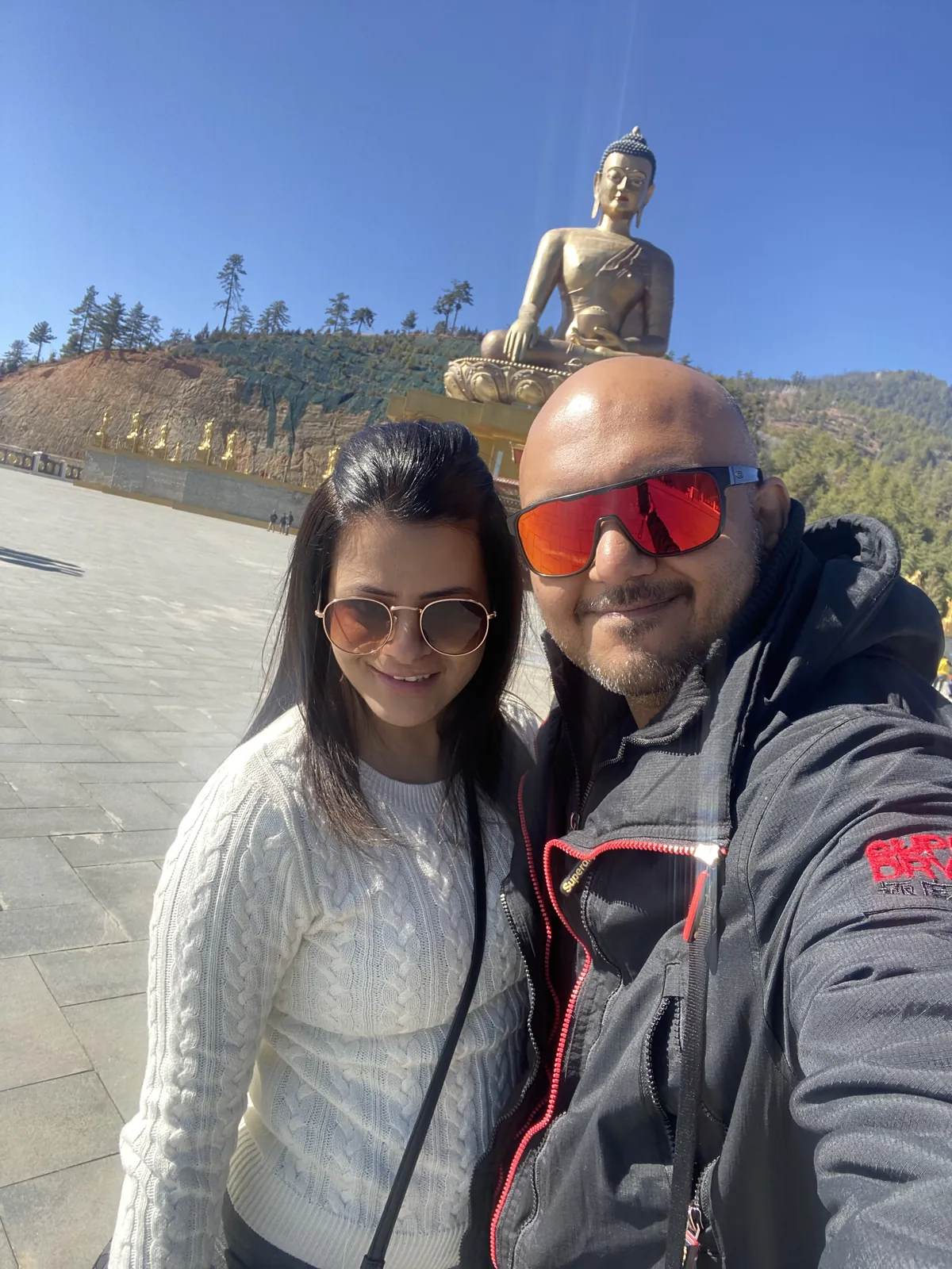 Couple posing large on the Bhutan group trip with One in the Orange Jacket.