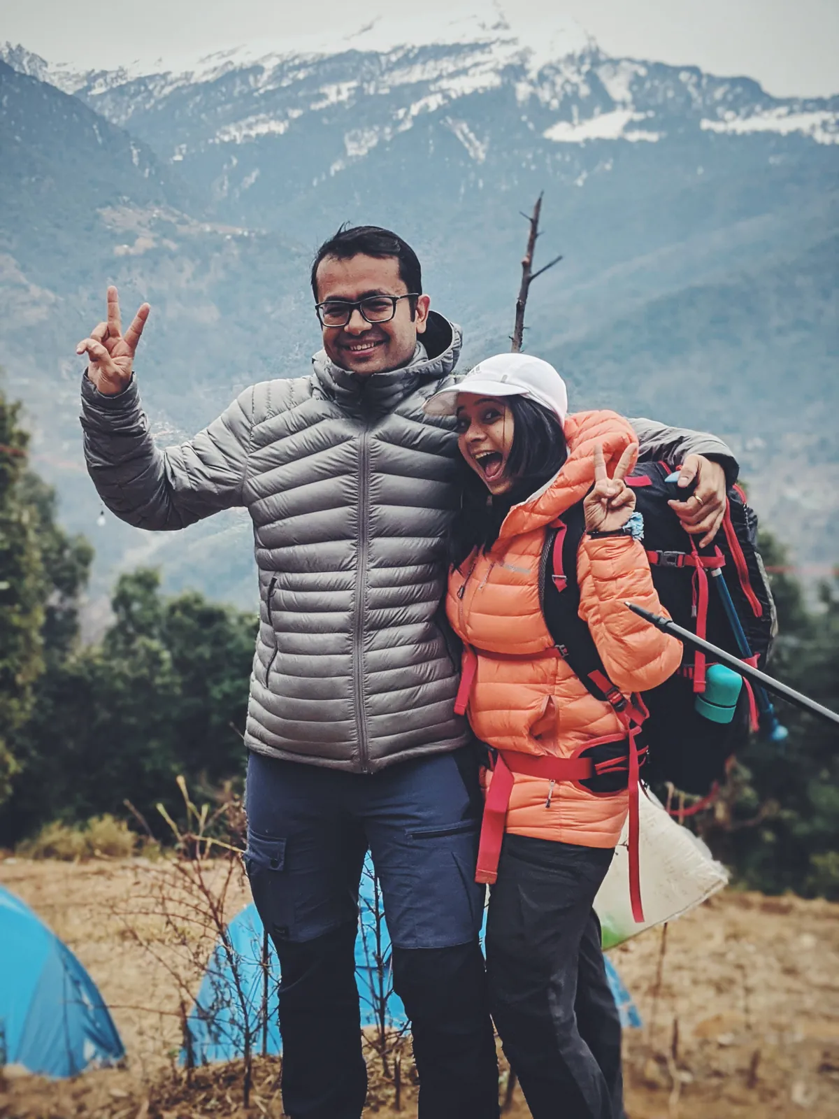 Mountain joyful couple celebrating on the Chandrashila group trip with One in the Orange Jacket.