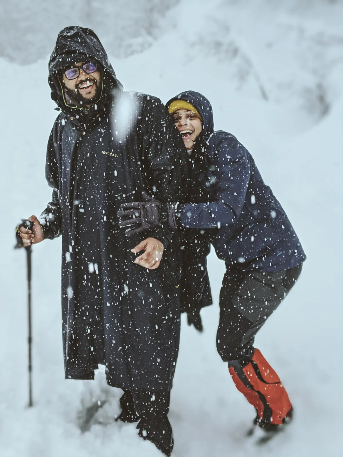 Mountain joyful couple embracing on the Chandrashila group trip with One in the Orange Jacket.