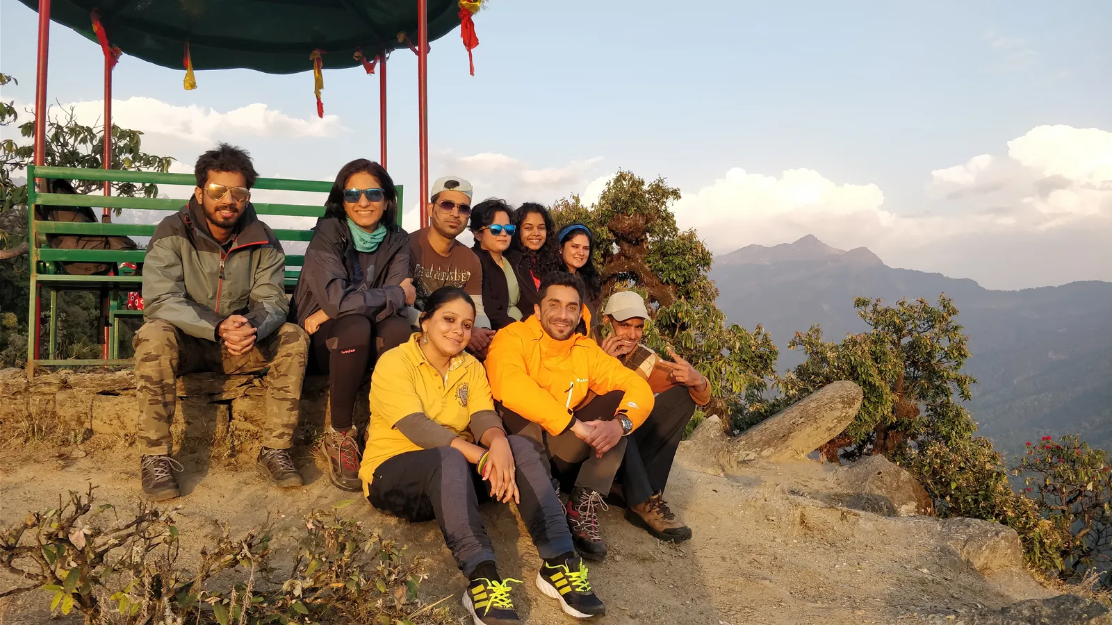 Mountain travelers posing scenic on the Chandrashila group trip with One in the Orange Jacket.