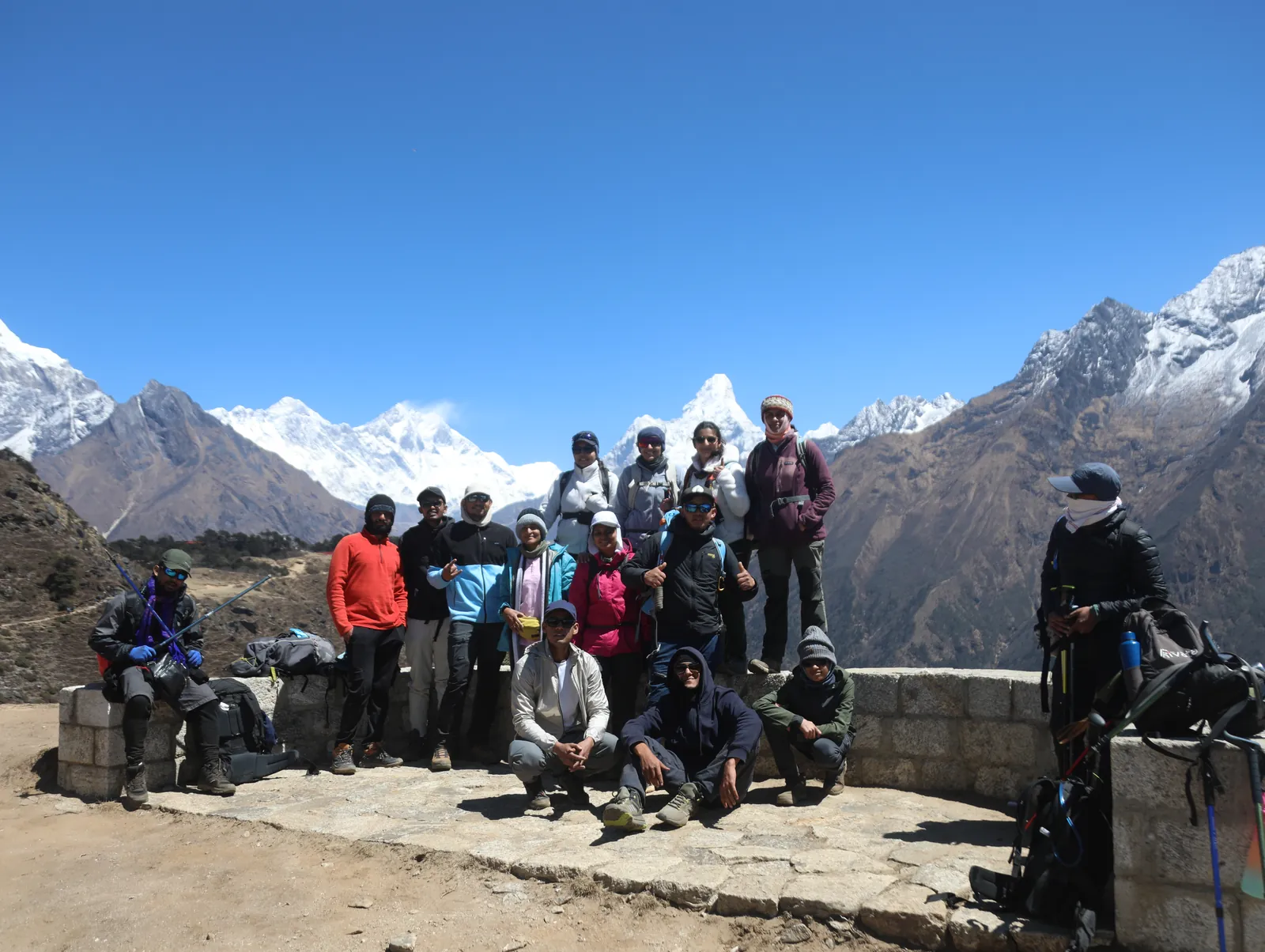 Mountain hikers posing on the Everest Base Camp group trip with One in the Orange Jacket.