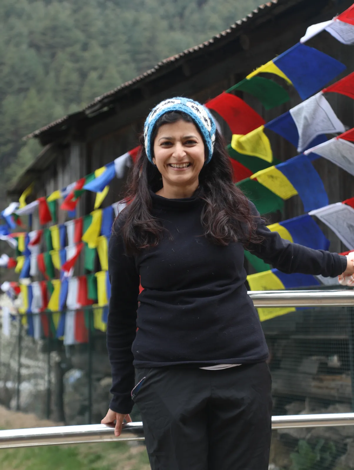 Smiling woman beanie poses on the Everest Base Camp group trip with One in the Orange Jacket.