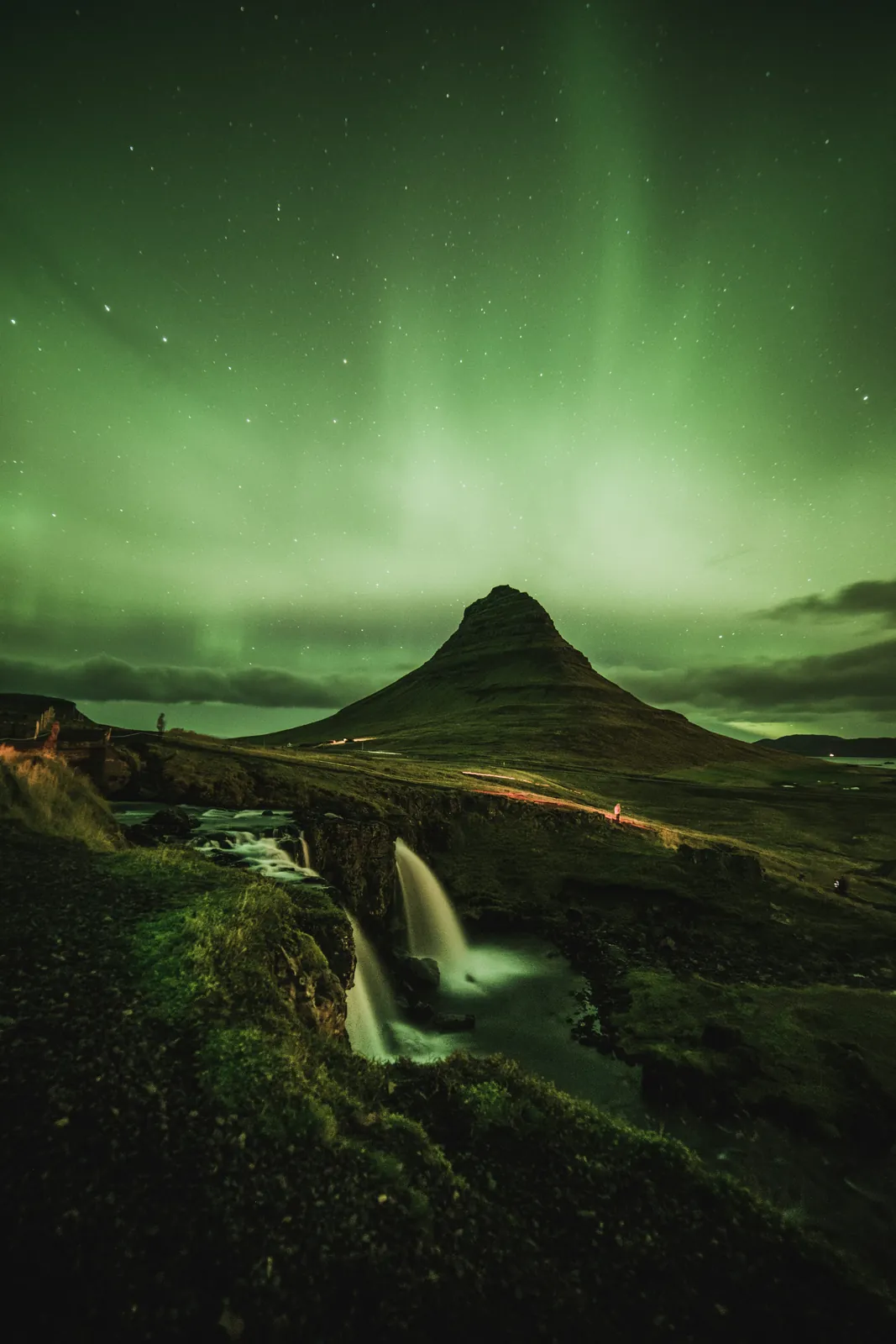 Water mountain aurora borealis waterfall on the Iceland group trip with One in the Orange Jacket.