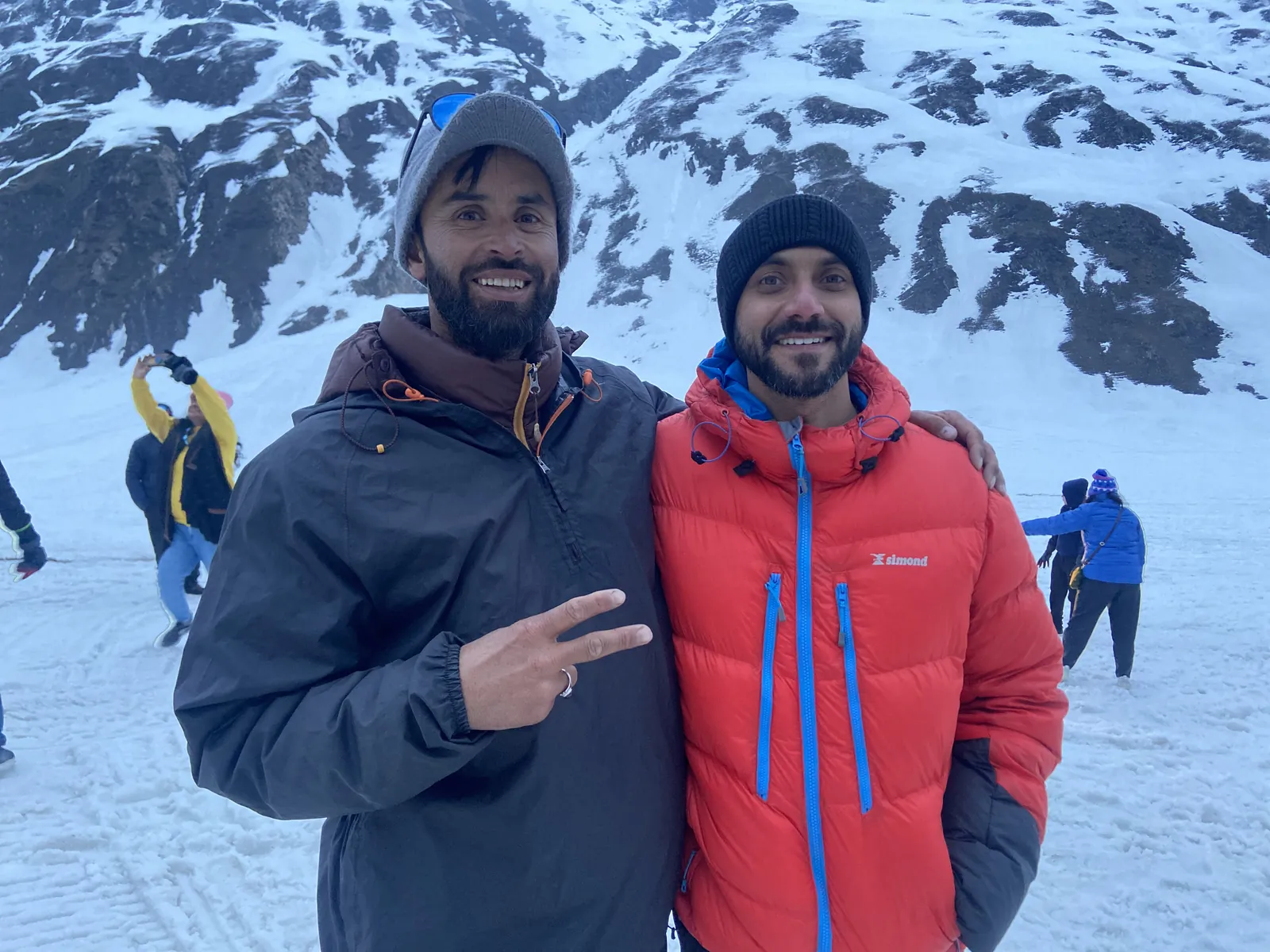 Mountain men smiling snowy on the Kashmir Great Lakes group trip with One in the Orange Jacket.