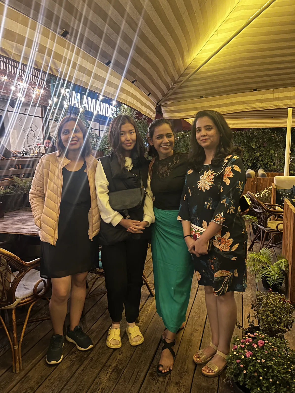 Night friends posing outdoor restaurant on the Kazakhstan group trip with One in the Orange Jacket.