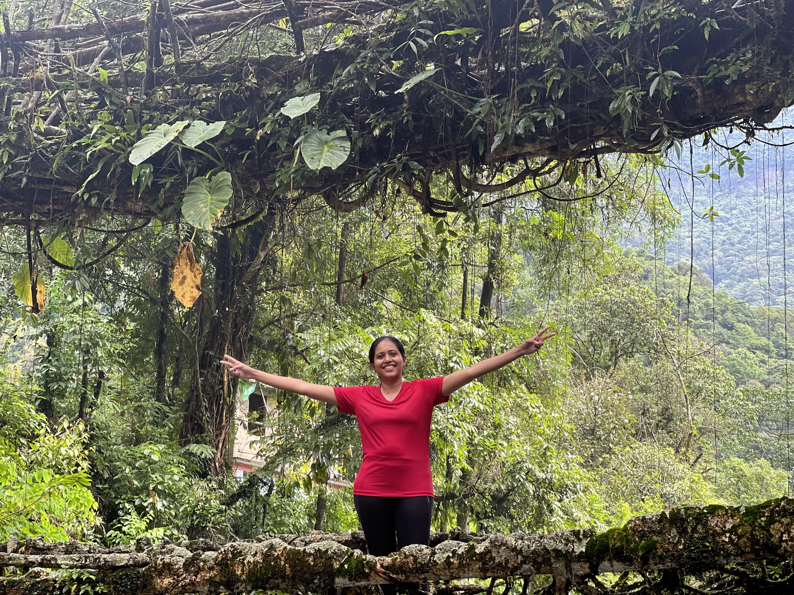 Joyful pose lush on the Meghalaya group trip with One in the Orange Jacket.