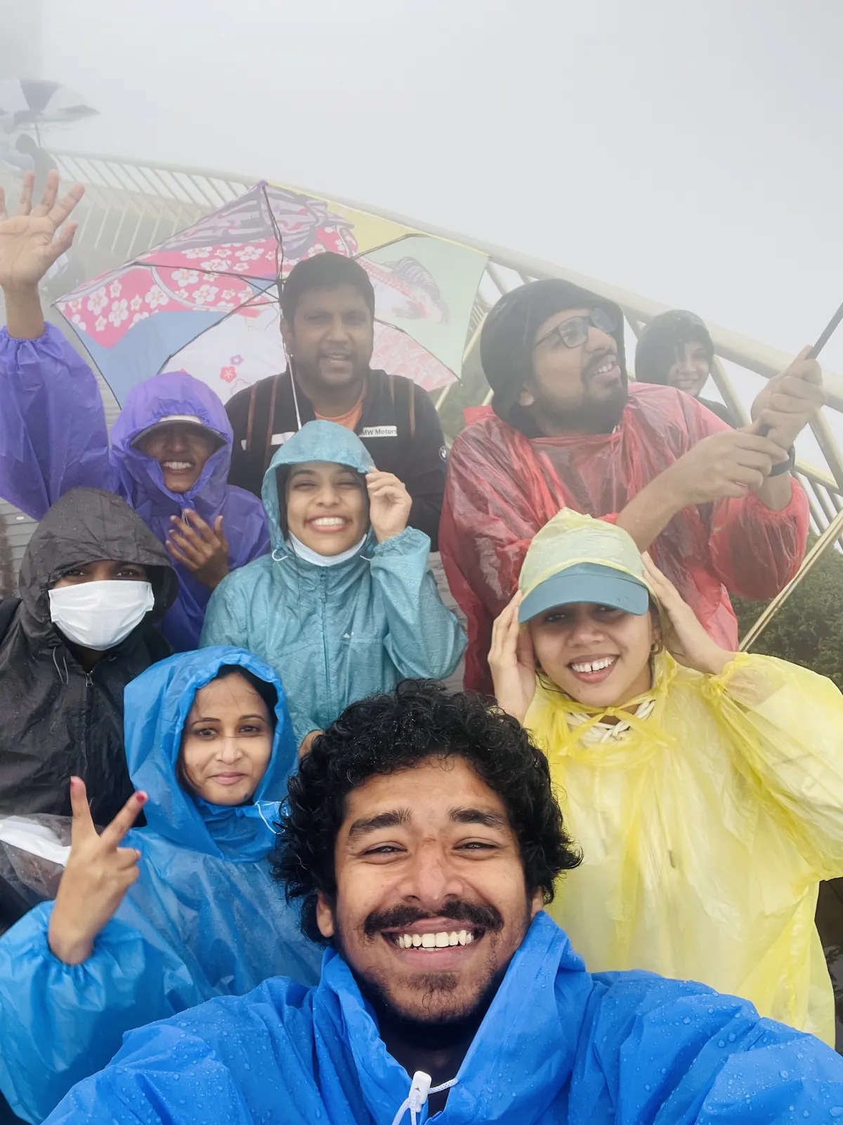 Smiles rain ponchos on the Meghalaya group trip with One in the Orange Jacket.