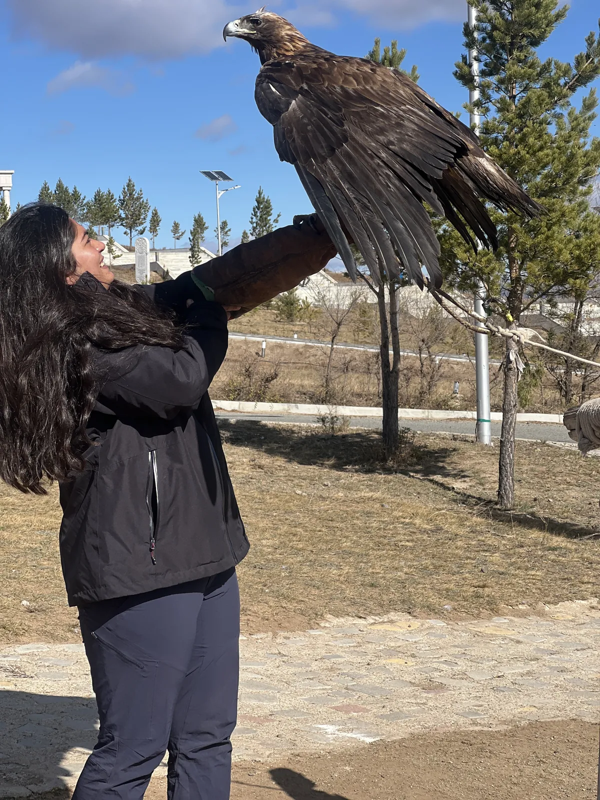 Woman smiles eagle on the Mongolia group trip with One in the Orange Jacket.