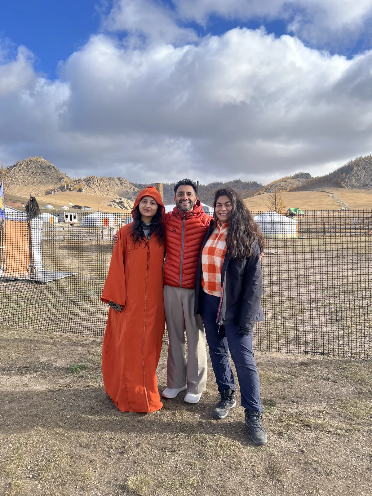 Mountain three smiling on the Mongolia group trip with One in the Orange Jacket.