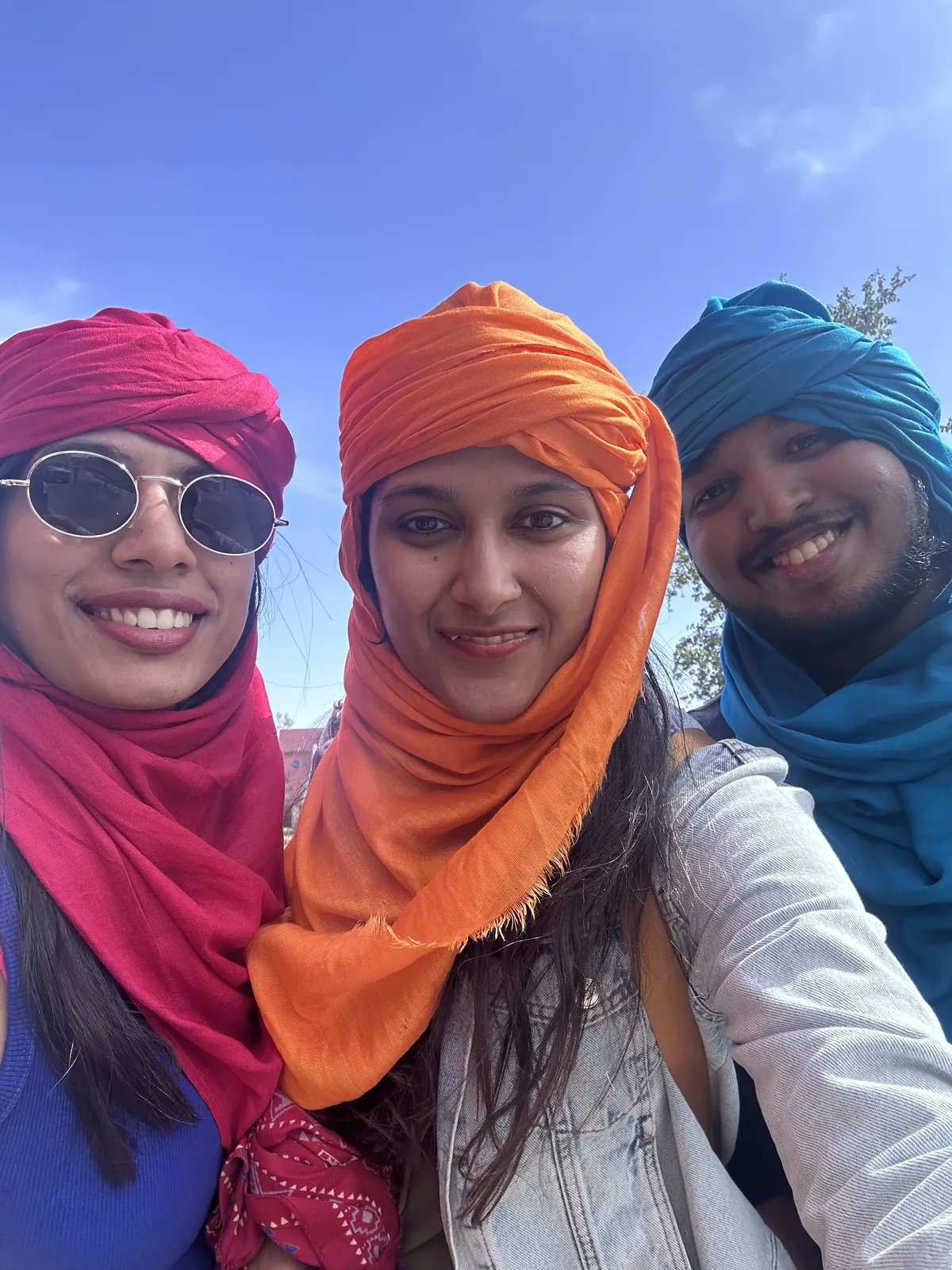 Three smiling wearing on the Morocco group trip with One in the Orange Jacket.
