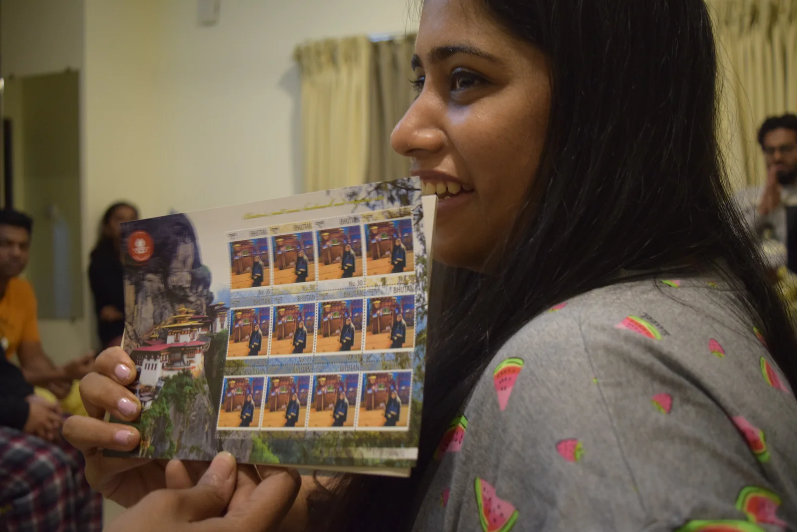 Tripper holding a sheet of custom Bhutan postage stamps at the Thimphu post office