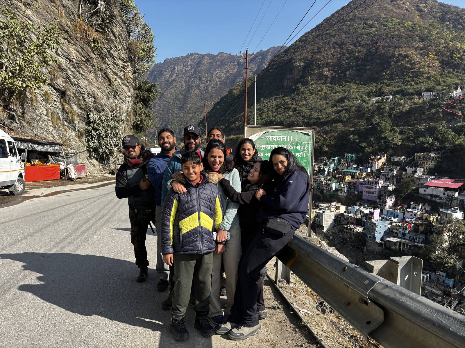 Trekkers posing on the road above Devprayag with the town and river confluence below