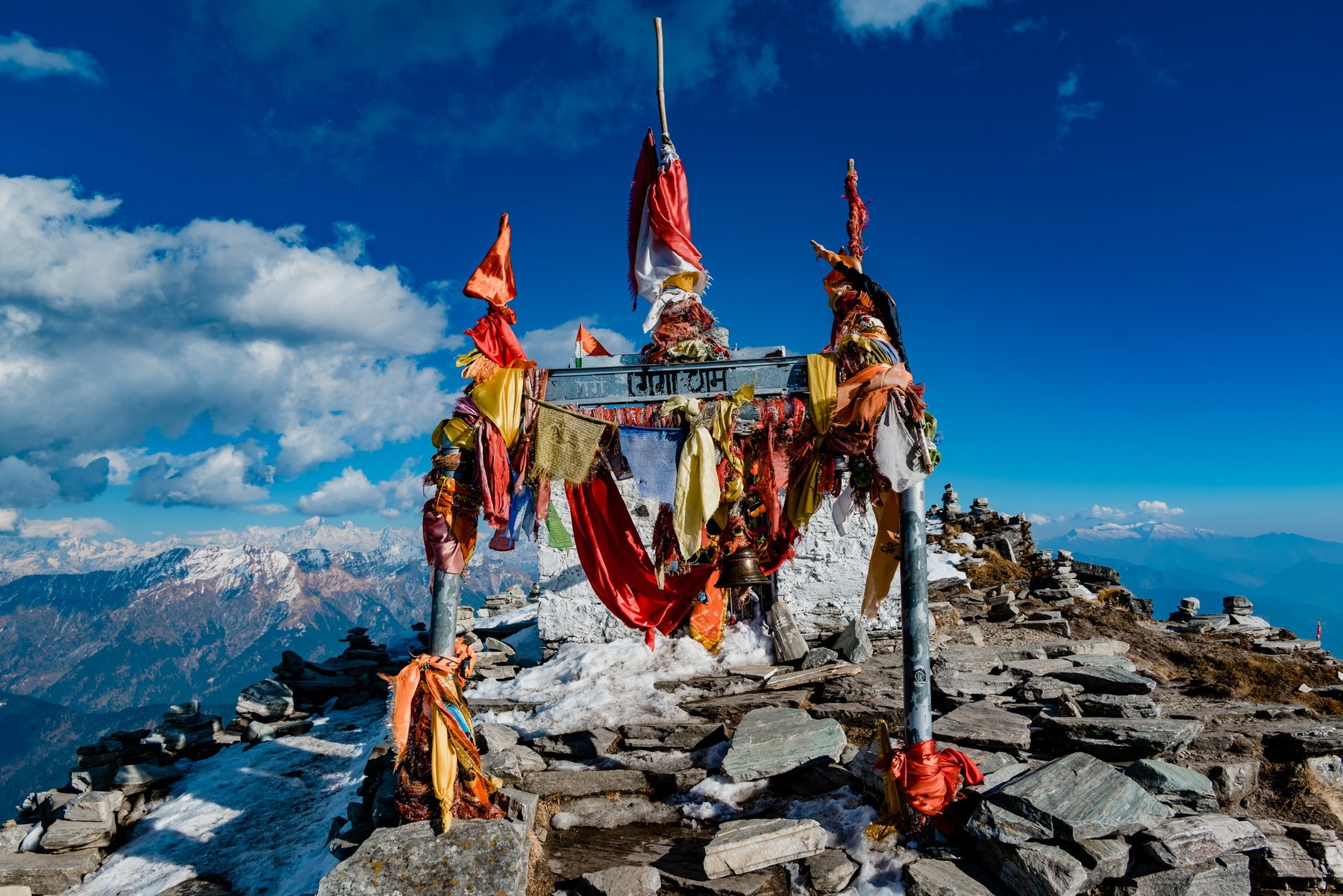 Summit shrine hung with prayer flags on Chandrashila with Himalayan peaks behind