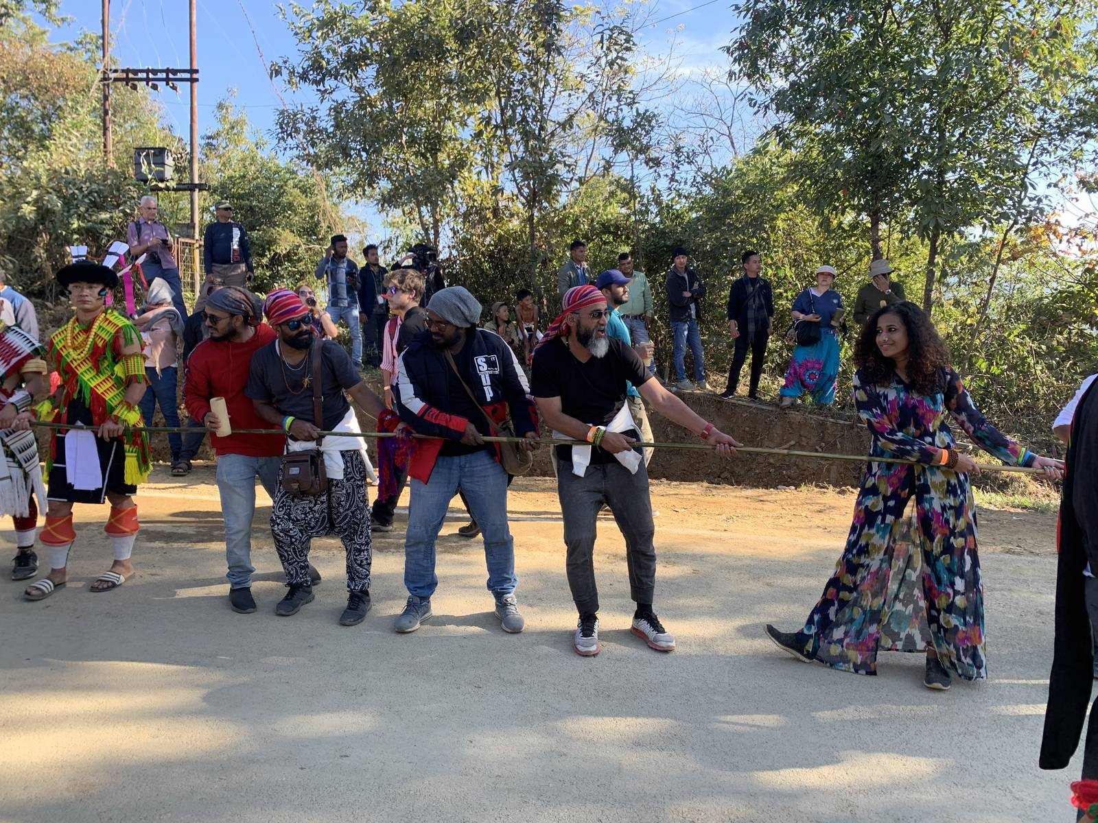 OJ trippers pulling the rope alongside Naga men in traditional dress