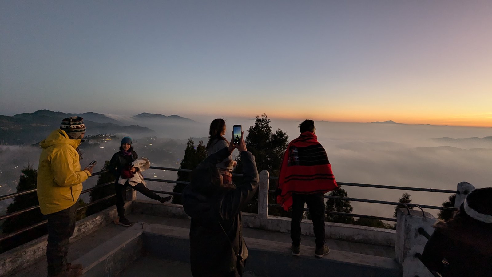 Group watching the sunrise over a sea of clouds from the Glory Peak viewing deck