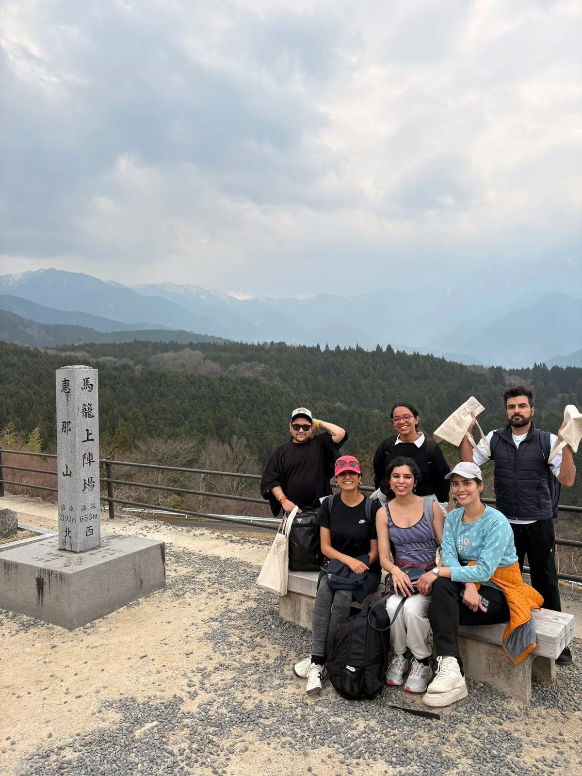 Japan, Day 8: OJ group resting at a stone trail marker on the Nakasendo with the valley behind