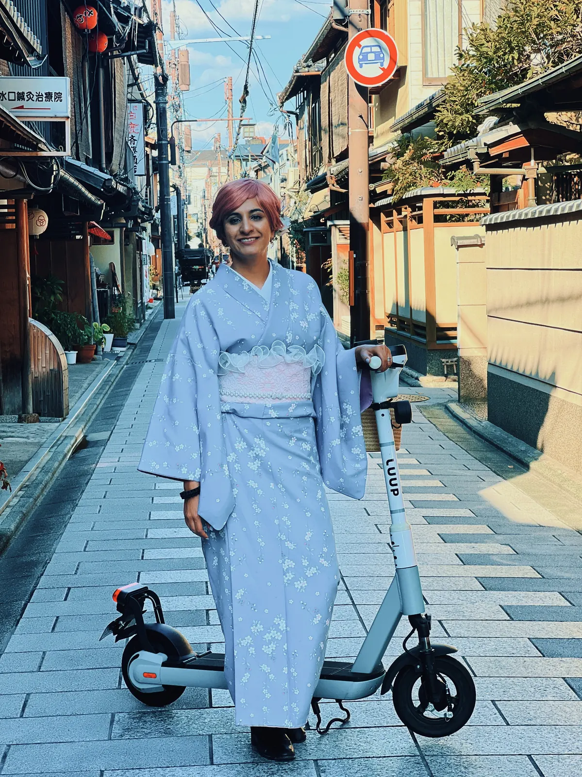 Japan Cherry Blossom, Day 7: A tripper in a light blue kimono with a rental e-scooter on a quiet Kyoto street