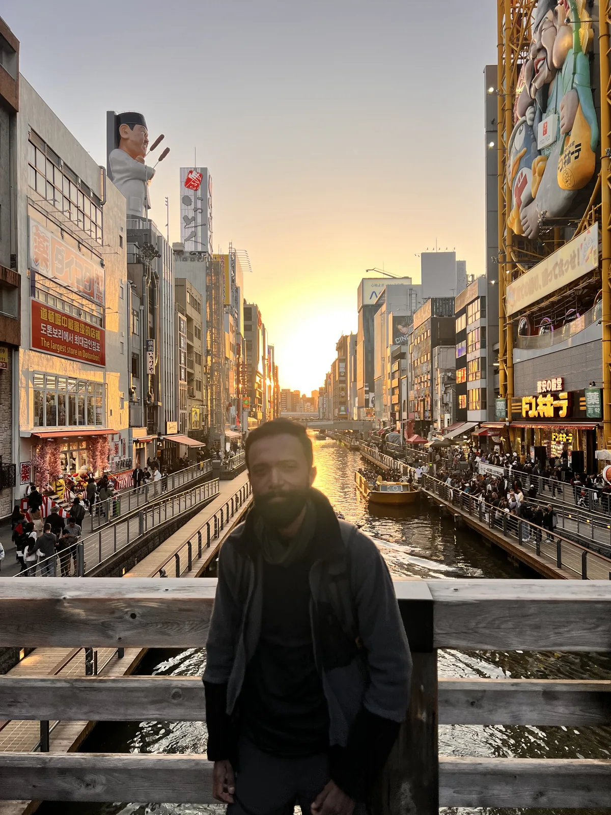 Japan Cherry Blossom, Day 8: A tripper on a bridge over the Dotonbori canal at golden hour in Osaka