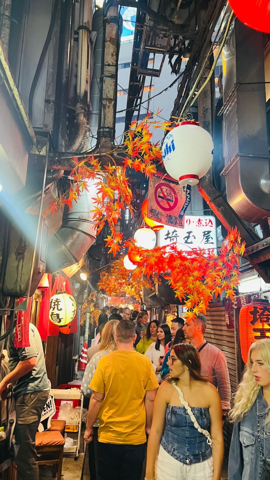 OJ group walking the lantern-lit Omoide Yokocho alley in Shinjuku