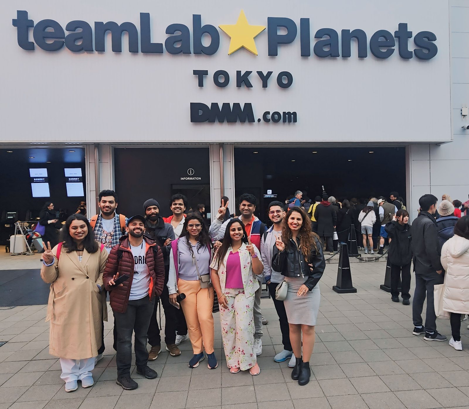 OJ group posing outside the teamLab Planets entrance in Tokyo
