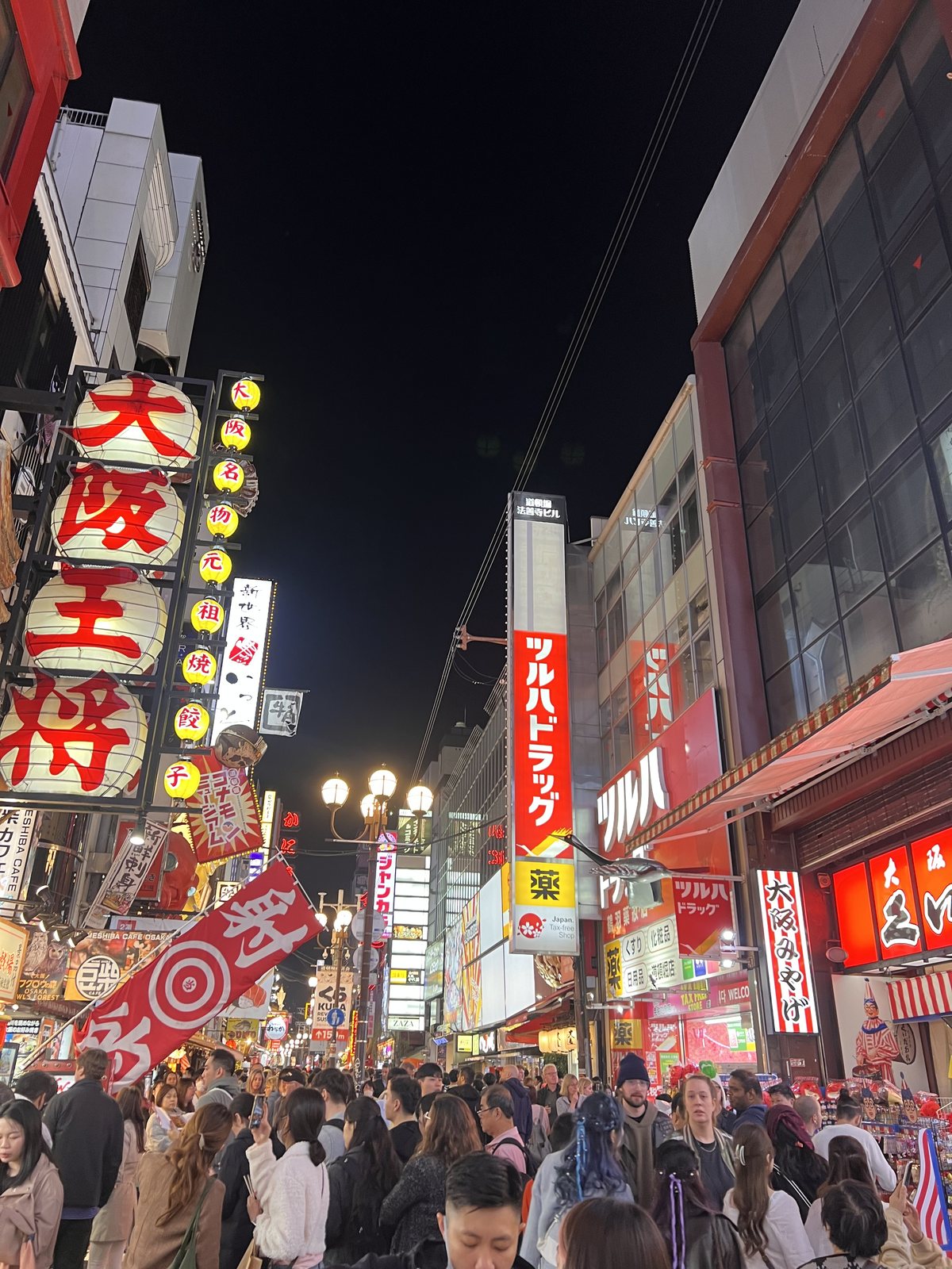 Crowded Dotonbori street in Osaka at night under big neon signs
