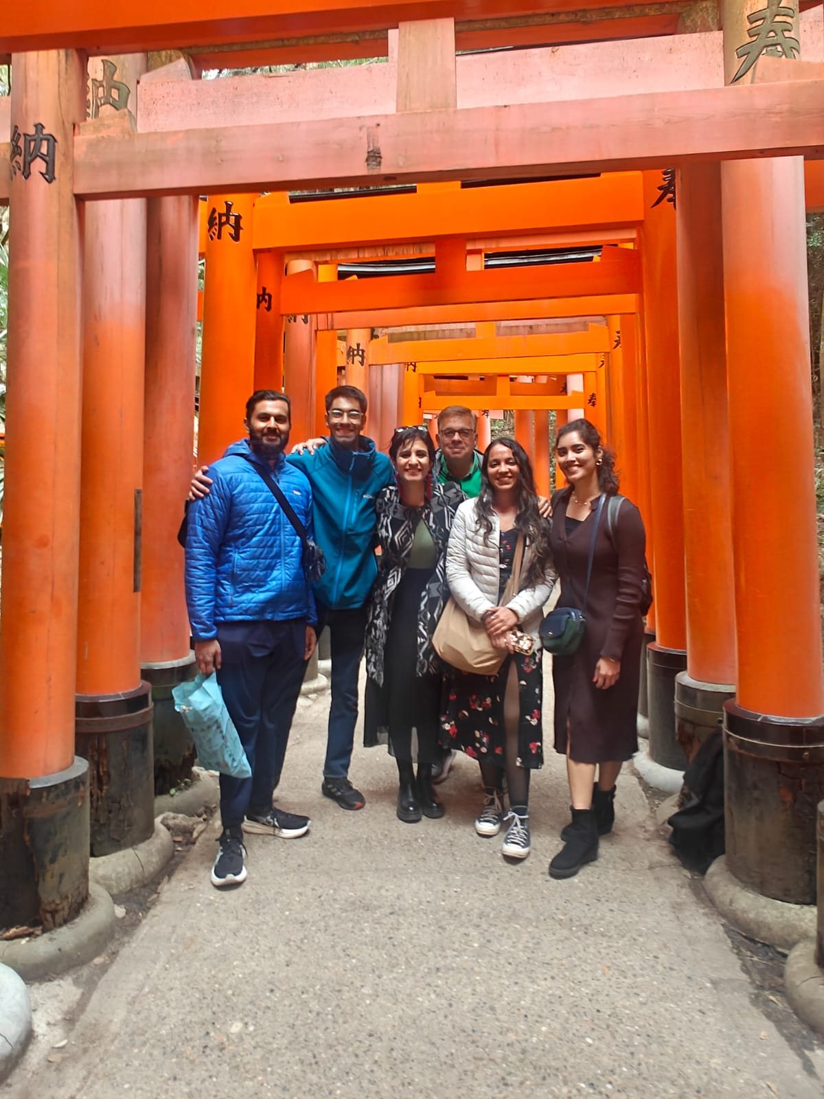 OJ group posing inside the orange torii gates at Fushimi Inari in Kyoto
