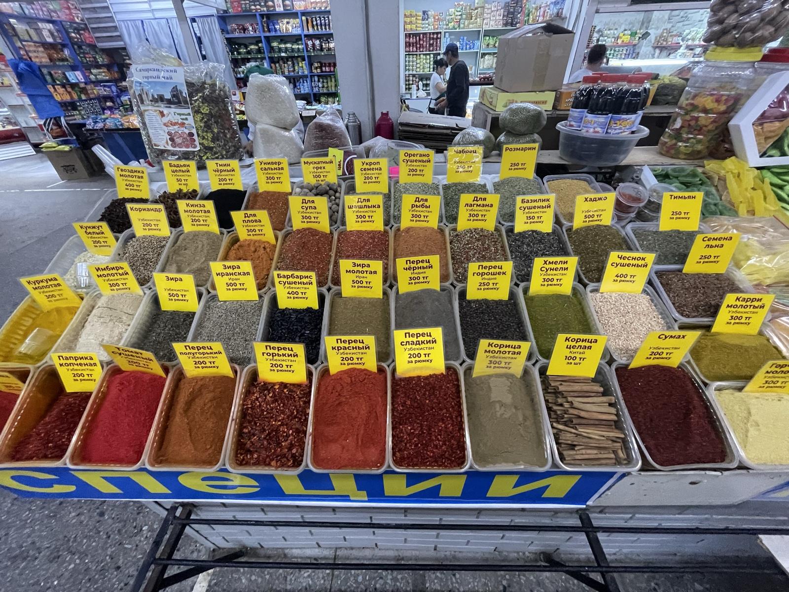 A market spice stall with rows of spices and yellow price tags
