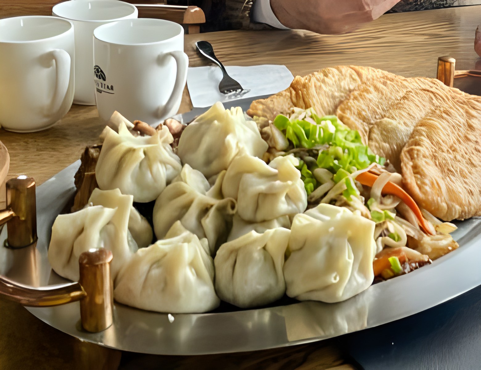 Plate of steamed buuz and fried khuushuur with tea