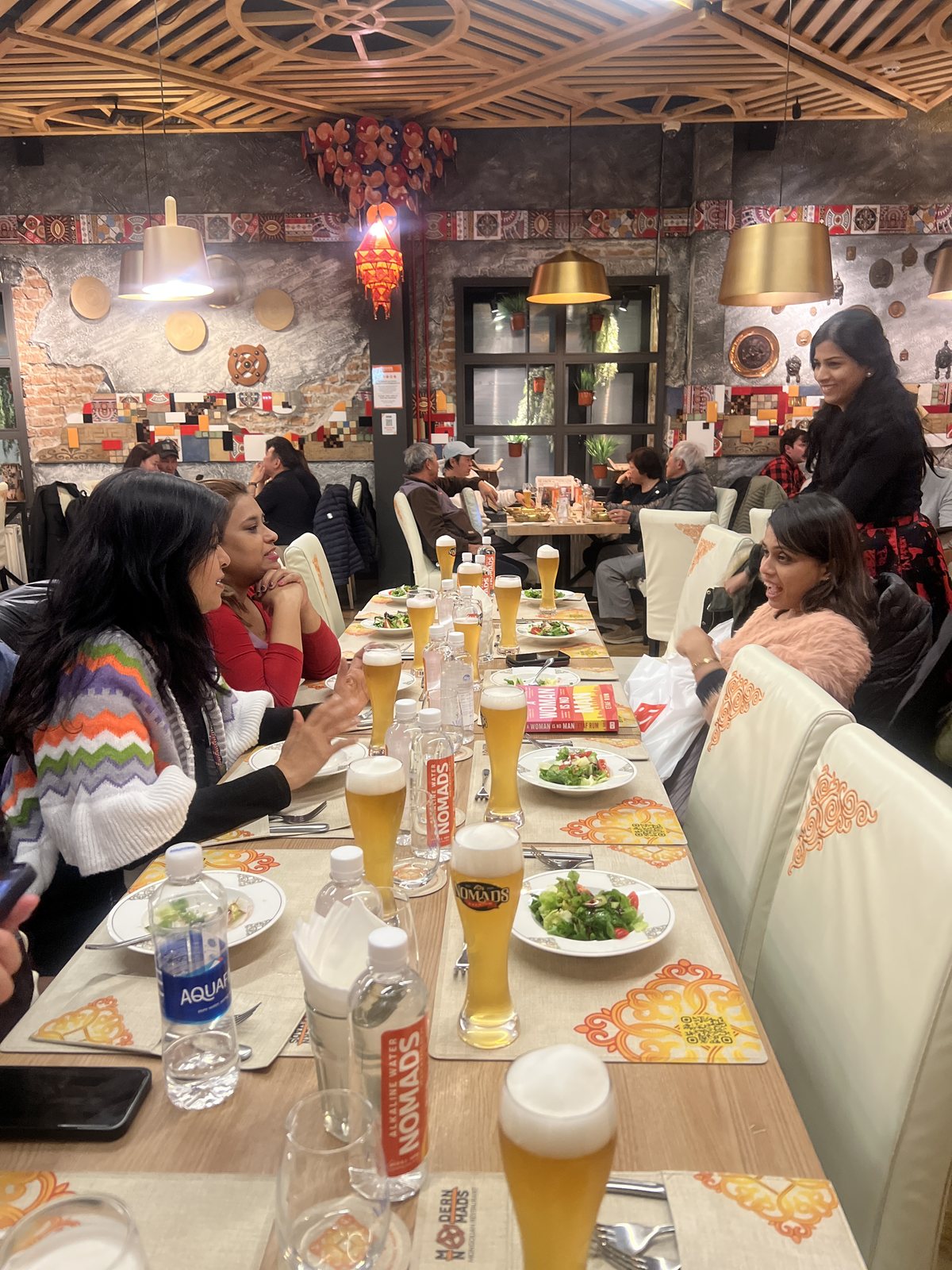 The whole group at a long dinner table in a Mongolian restaurant
