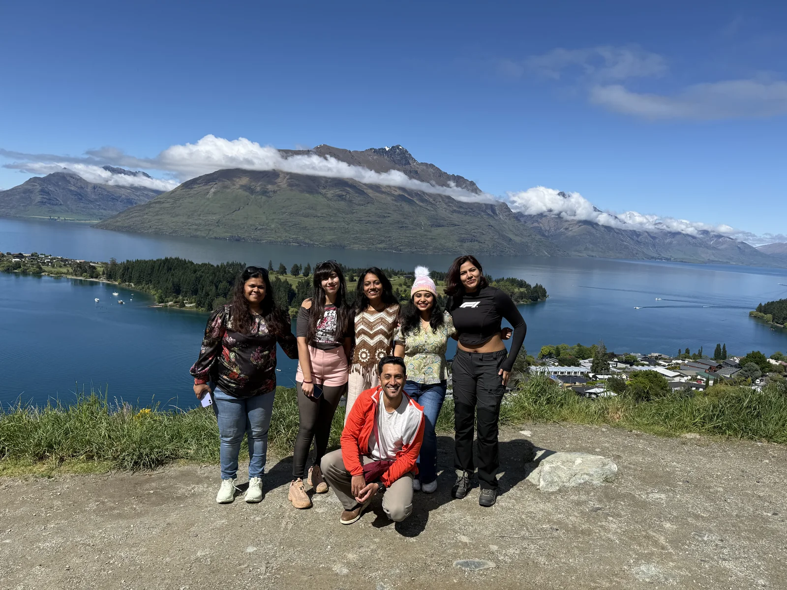 Six OJ trippers on a hilltop above Lake Wakatipu with the Remarkables behind