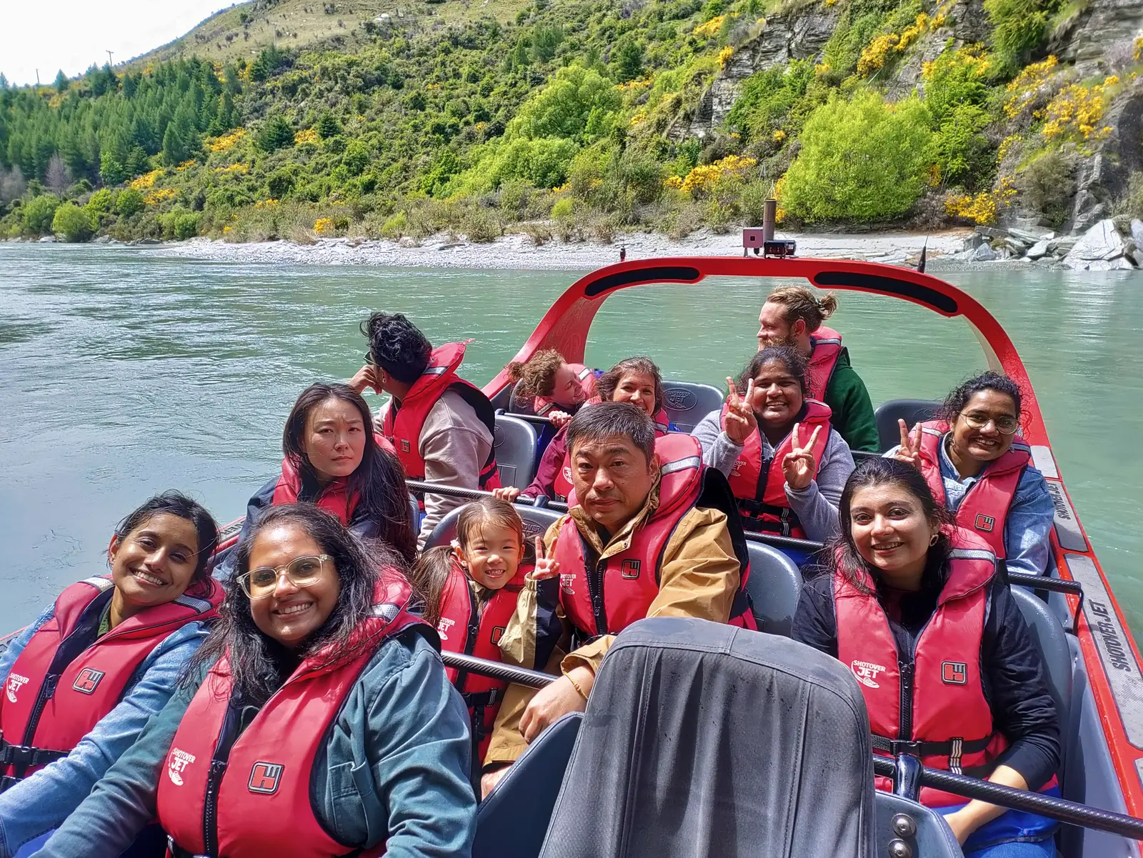 OJ group in red life jackets grinning on a Shotover Jet boat