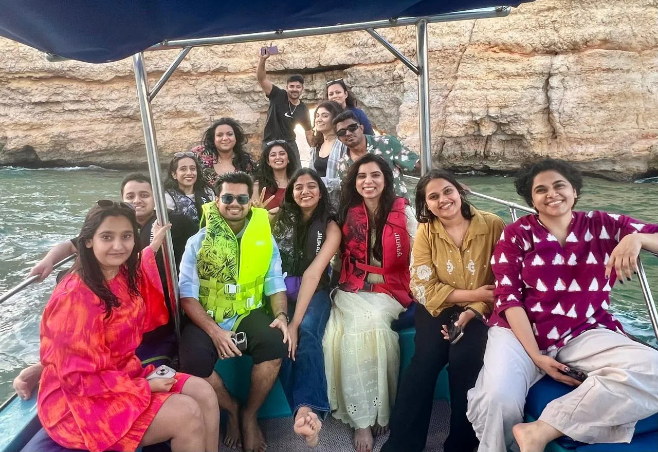 The OJ crew on a sunset boat ride off the Omani coast, sea cliff behind