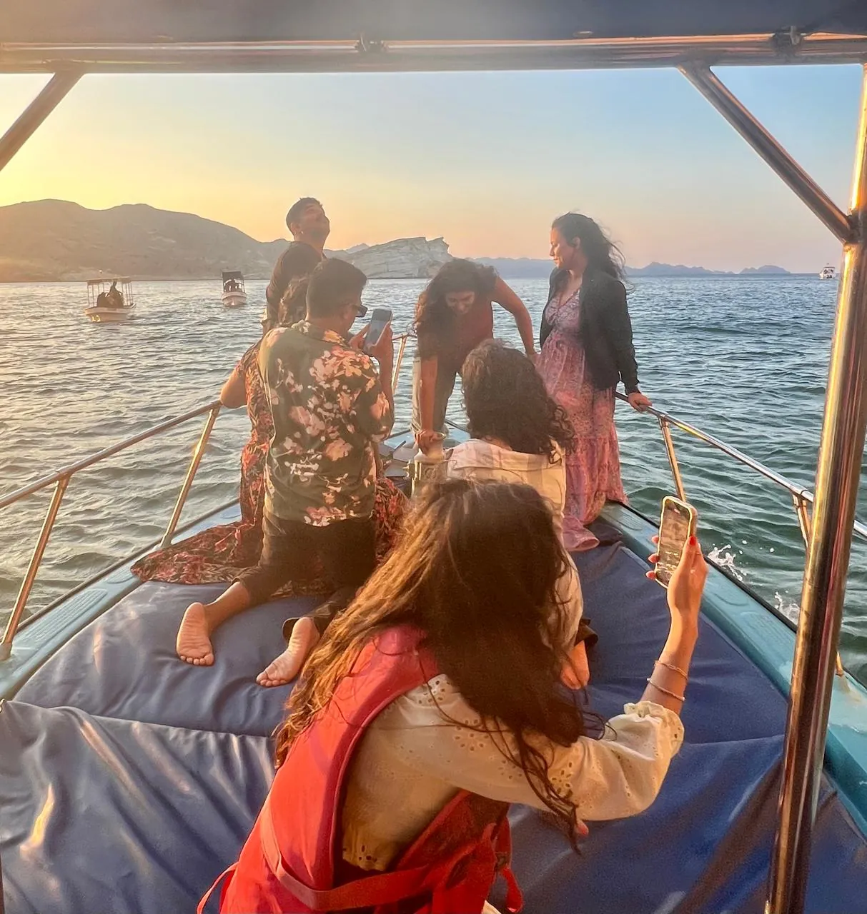 OJ crew gathered at the bow of the boat at sunset