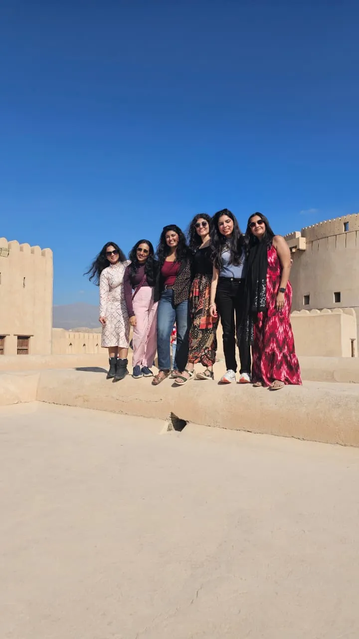 OJ crew on the ramparts of Nizwa Fort under a blue sky