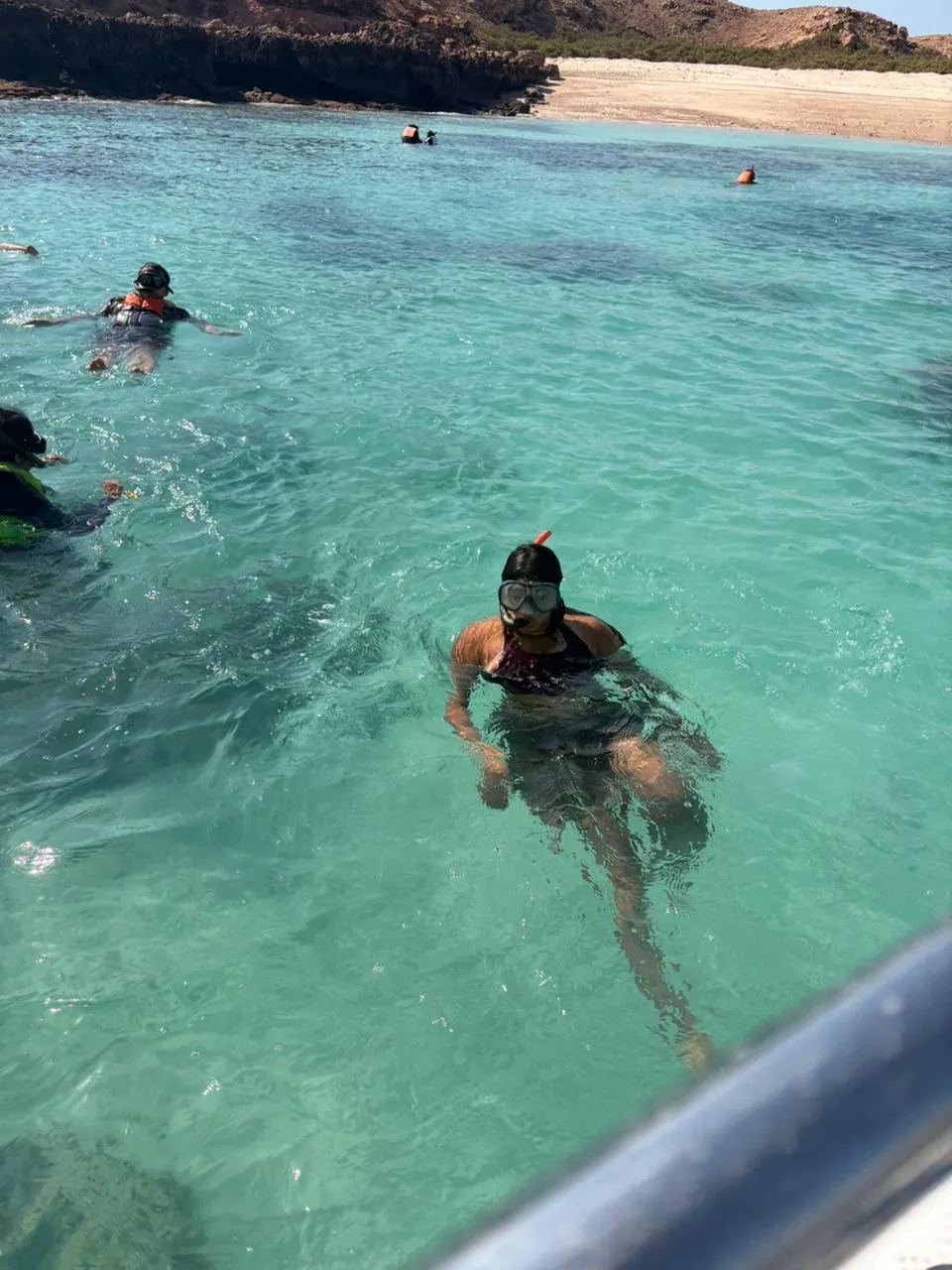 An OJ tripper snorkelling in clear turquoise water