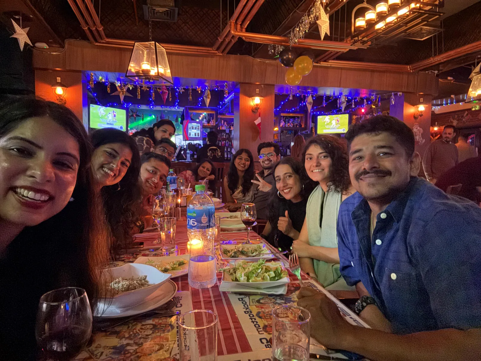 The whole OJ crew around a long dinner table, laughing
