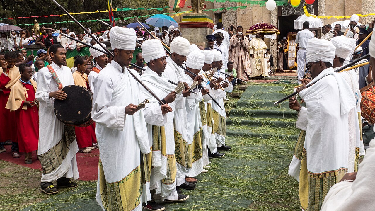 White-robed crowds and priests with ceremonial umbrellas at Timkat in Ethiopia