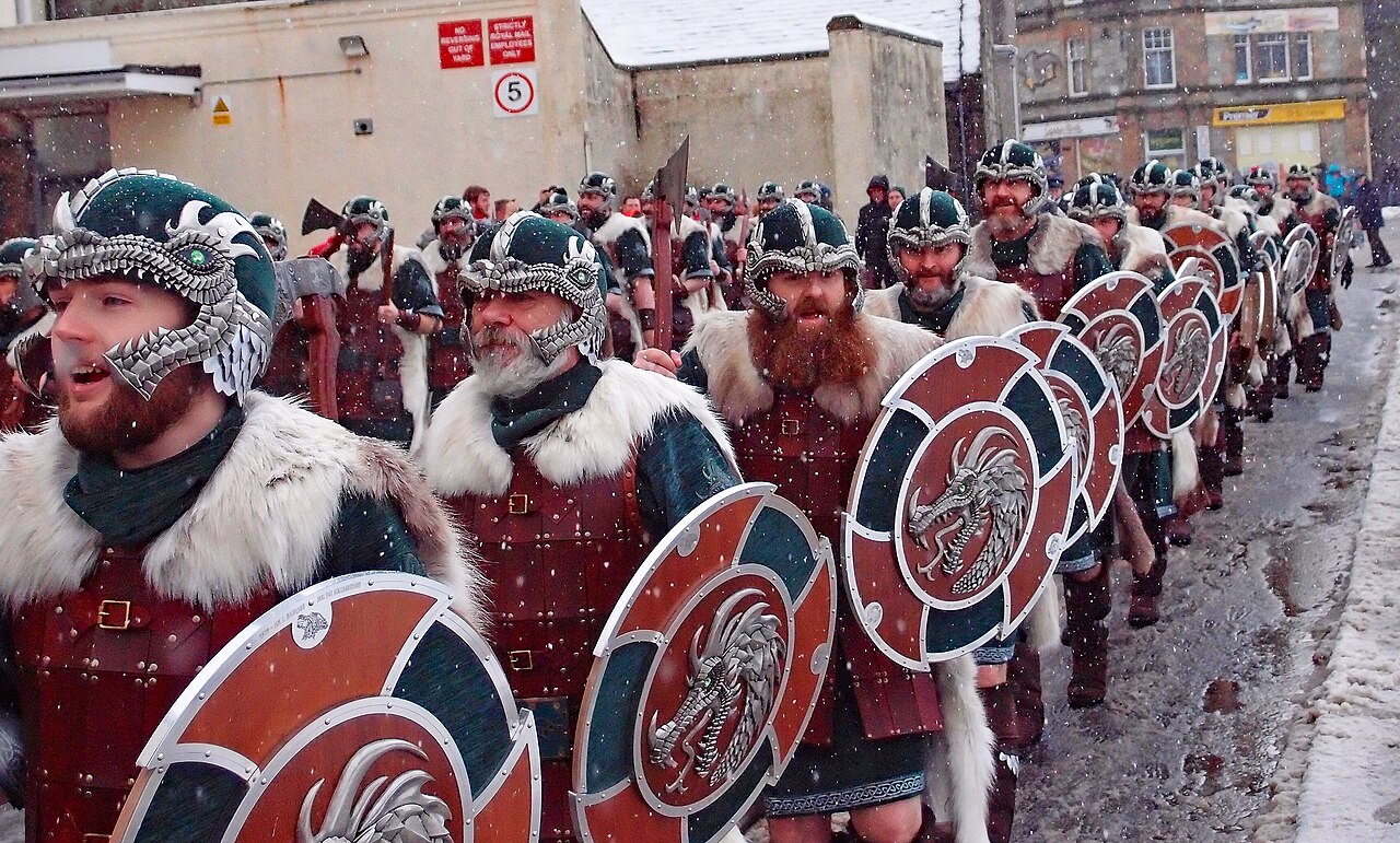 Torch-bearing guizers and a Viking galley at Up Helly Aa in Shetland